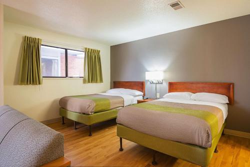 a hotel room with two beds and a window at Studio 6 Extended Stay - Greensboro, NC in Greensboro