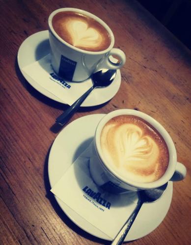 two cups of coffee sitting on plates on a table at Piwnica Rycerska Kęty in Kęty