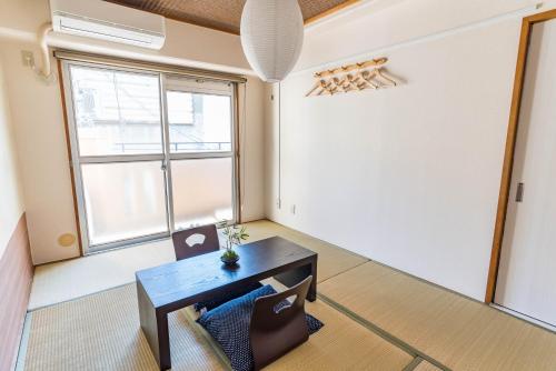a living room with a table and a window at Bijou Suites Kokoro in Osaka