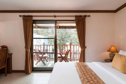 a bedroom with a bed and a balcony at Jomtien Boathouse in Jomtien Beach