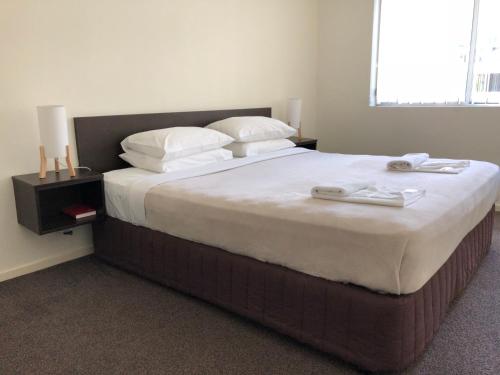 a bedroom with a large bed with white sheets and pillows at Splendido Resort Apartments in Gold Coast