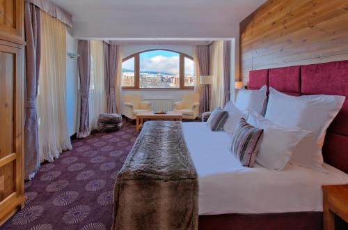a hotel room with a bed with a large window at Kempinski Hotel Grand Arena Bansko in Bansko
