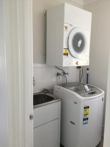 a small kitchen with a sink and a microwave at Splendido Resort Apartments in Gold Coast