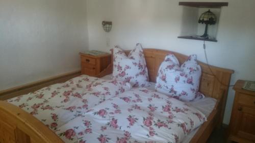 a bed with red and white sheets and pillows at Ferienhaus am Mühlbach in Kinding