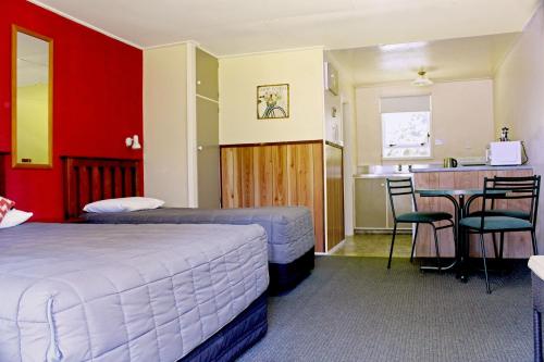 a hotel room with two beds and a kitchen at Fairy Springs Motel in Rotorua