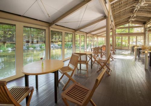 a dining room with tables and chairs and windows at Kinugawa Park Hotels in Nikko