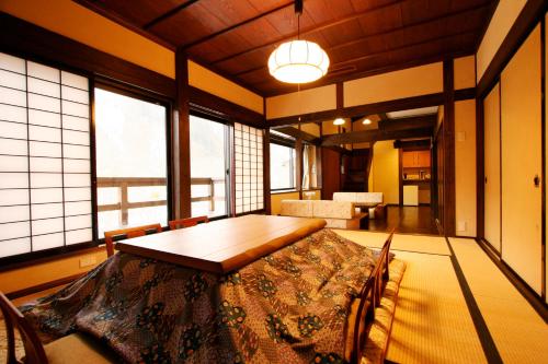 a dining room with a table and some windows at Yamazatonoiori Soene in Takayama
