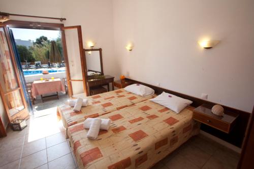 a bedroom with a large bed and a balcony at Anna Studios in Agios Prokopios