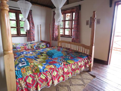 1 dormitorio con 1 cama con colcha colorida en Itambira Island, Seeds of Hope en Chabahinga