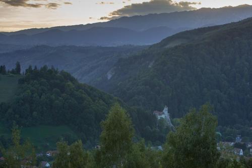 a castle in the middle of a valley with mountains at Bran Monte Crai Chalet in Bran