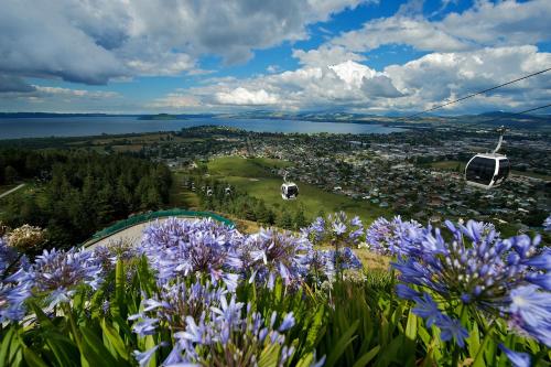a view of a park with purple flowers and a gondola at Fairy Springs Motel in Rotorua