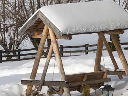 a wooden picnic table covered in snow at Bran Monte Crai Chalet in Bran