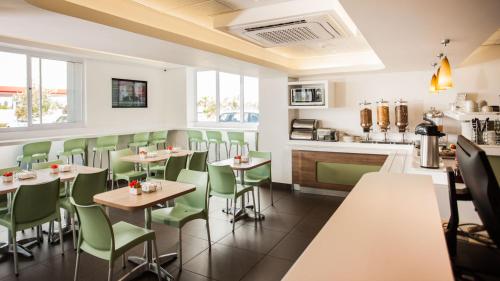 a restaurant with tables and chairs and a counter at SUN1 MILNERTON in Cape Town