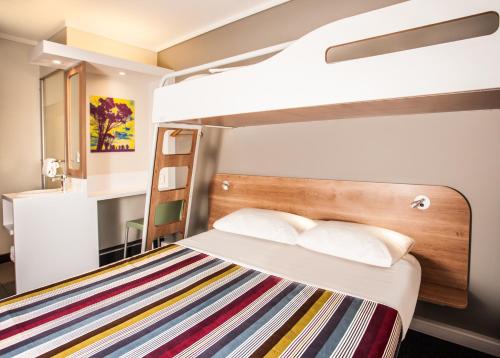 a bunk bed in a small room with a ladder at SUN1 MILNERTON in Cape Town