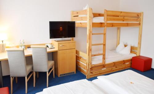 a room with a bunk bed and a desk with a computer at Hotel Nummerhof in Erding