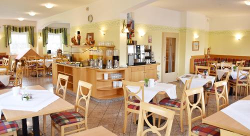 a restaurant with tables and chairs and a kitchen at Hotel Nummerhof in Erding