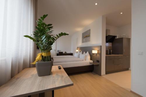 une chambre d'hôtel avec un lit et une plante en pot dans l'établissement Vitus Steyr Hotel & SPA Suites, à Steyr