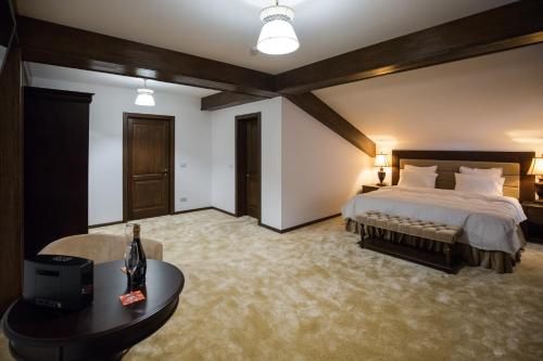 a bedroom with a large bed and a table at Bran Monte Crai Chalet in Bran