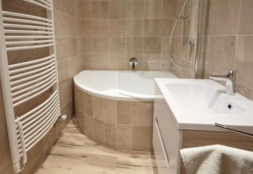 a bathroom with a tub and a sink and a shower at Residence U Černé Věže České Budějovice in České Budějovice