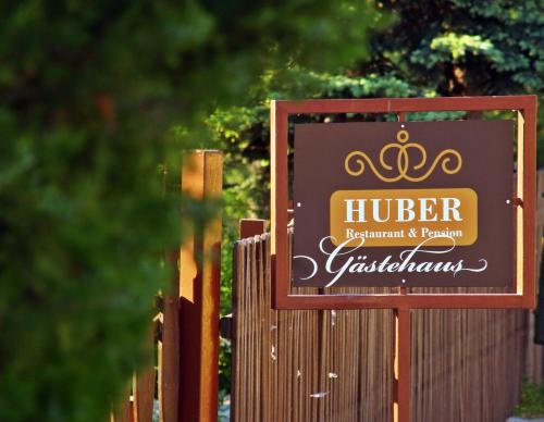 a sign for a hotel on a fence at Huber Vendégszobák in Fertőrákos