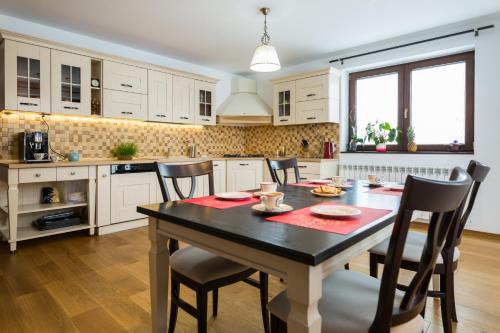 a kitchen with a table and chairs in a room at Bran Monte Crai Chalet in Bran