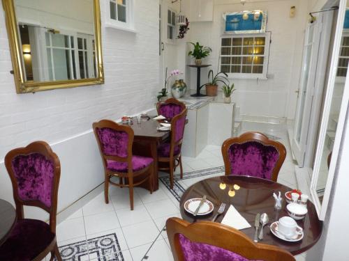 a dining room with purple chairs and tables at Lensfield Hotel in Cambridge
