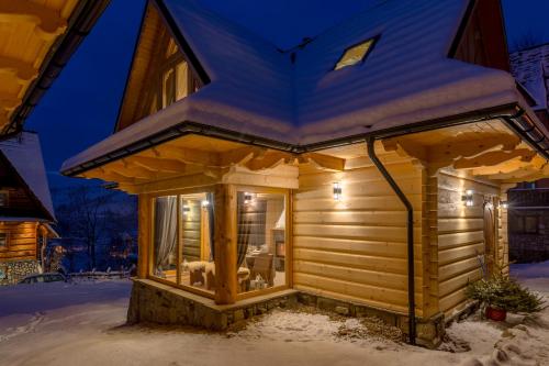 a log cabin in the snow at night at Zacisze Galicove in Zakopane