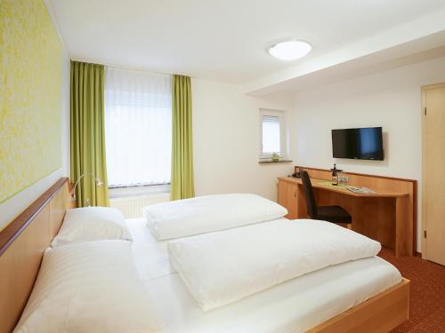 a hotel room with two beds and a desk at Hotel Gasthof zum Biber in Motten