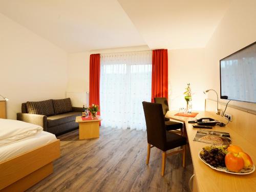 a hotel room with a bed and a desk with a computer at Hotel Gasthof zum Biber in Motten