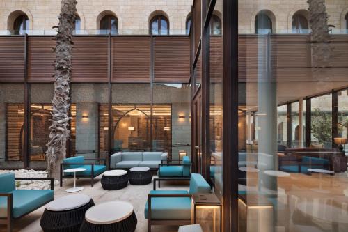 a lobby of a building with blue chairs and tables at The Setai Tel Aviv, a Member of the leading hotels of the world in Tel Aviv