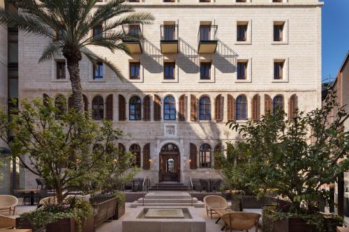 a building with a palm tree in front of it at The Setai Tel Aviv, a Member of the leading hotels of the world in Tel Aviv