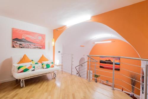 een oranje en witte kamer met een bank in een kamer bij Casa Le Volte in Napels