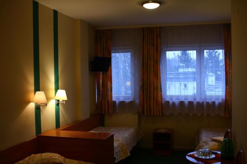a hotel room with two beds and two windows at Amicus Żoliborz in Warsaw