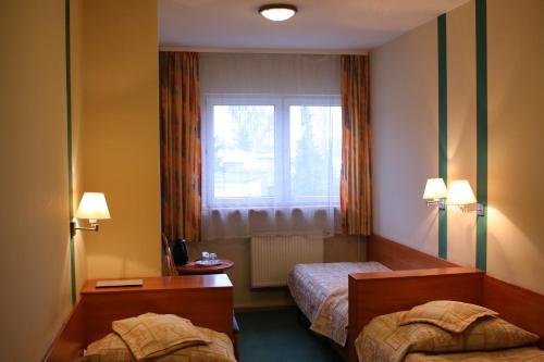 a hotel room with two beds and a window at Amicus Żoliborz in Warsaw