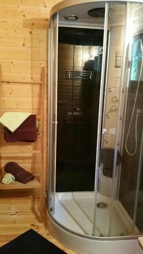 - une douche dans une chambre dotée d'un mur en bois dans l'établissement La cabane du pommier, à Orelle