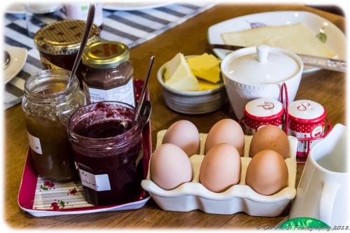 a table with eggs and jars of jam and butter at Confluences in Walcourt