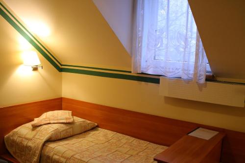 a small bedroom with a bed and a window at Amicus Żoliborz in Warsaw