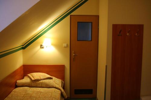 a small bedroom with a bed and a staircase at Amicus Żoliborz in Warsaw