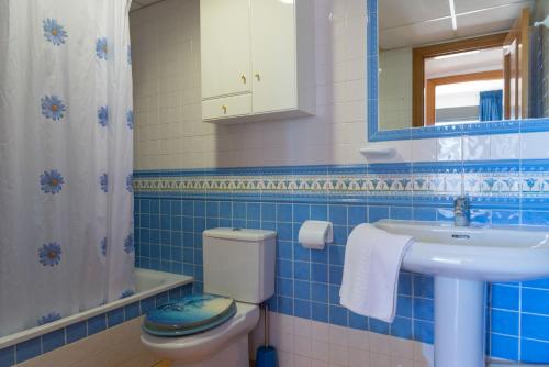 La salle de bains est pourvue de carrelage bleu, de toilettes et d'un lavabo. dans l'établissement Apartamento La Niña 18 by Gestaltur, à Benidorm