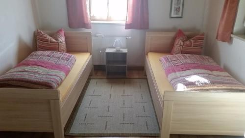 two beds in a small room with a window at Ferienhaus Kammern in Bad Koetzting
