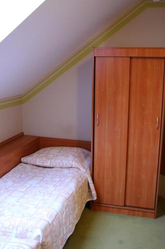 a bedroom with a bed and a wooden cabinet at Amicus Żoliborz in Warsaw