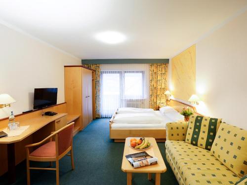 Hotel Gasthof zum Biber في Motten: غرفه فندقيه بسرير واريكه