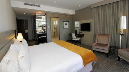 a hotel room with a large bed and a desk at Coastlands Musgrave Hotel in Durban