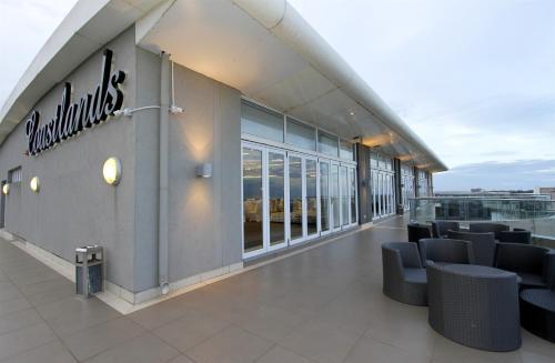 a building with chairs and a sign on the side of it at Coastlands Musgrave Hotel in Durban