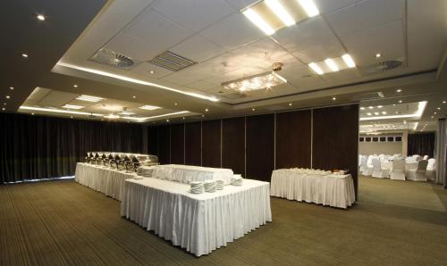 a row of tables in a room with white tablecloths at Coastlands Musgrave Hotel in Durban