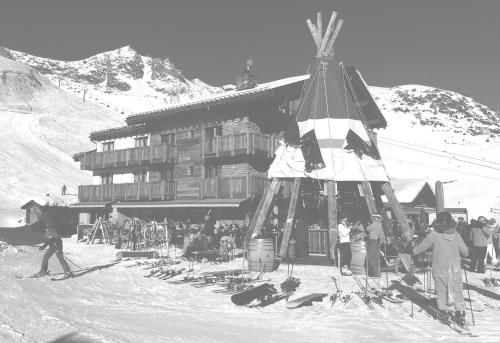 a group of people standing in front of a ski lodge at Hotel Alpina in Fiesch