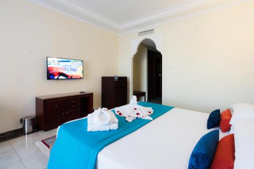 a bedroom with a bed with towels on it at Pickalbatros Aqua Fun Club All Inclusive in Marrakech