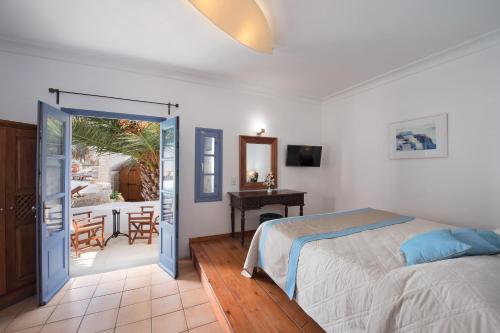 a bedroom with a bed and a patio with a table at Meltemi Suites in Perissa