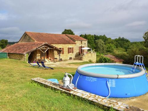 a large swimming pool in front of a house at Heavenly holiday home with pool in Villefranche-du-Périgord