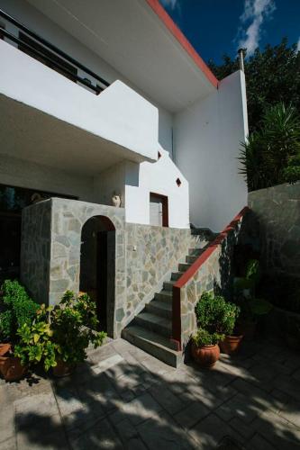 a house with a staircase and some potted plants at Archontika Apartments in Kerames